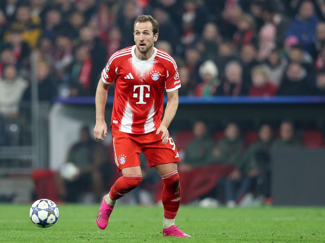 Harry Kane in Aktion auf dem Rasen, vor ihm fliegt der Champions-League-Ball knapp über dem Rasen.