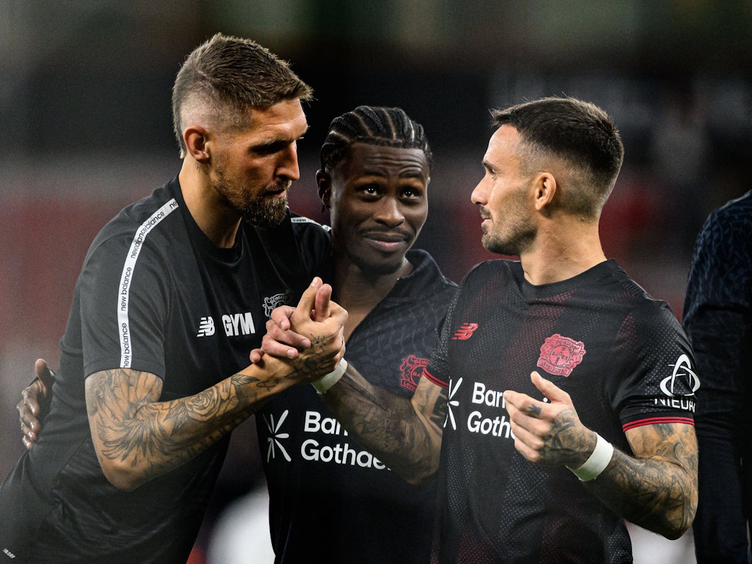 Robert Andrich, Nathan Tella und Aleix Garcia klatschen sich ab.