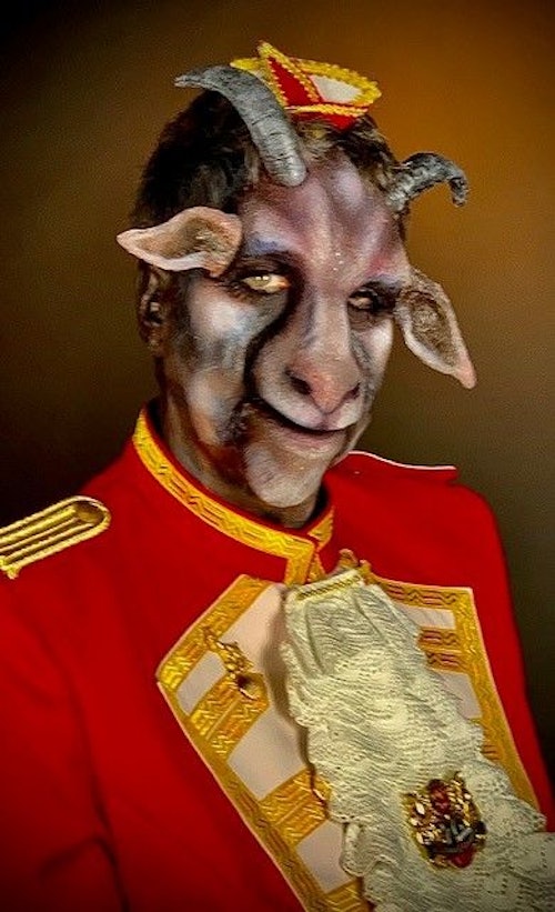 Ein Mann als Ziegenbock geschminkt