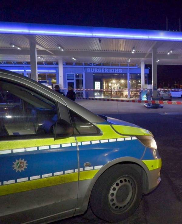Einsatzwagen der Polizei stehen auf dem Gelände einer Tankstelle.