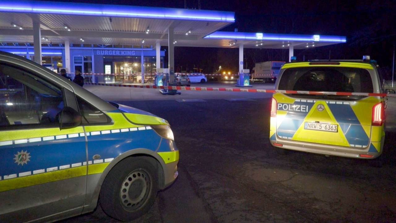 Einsatzwagen der Polizei stehen auf dem Gelände einer Tankstelle.