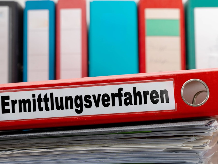 Roter Ordner auf Aktenstapel mit anderen Ordnern