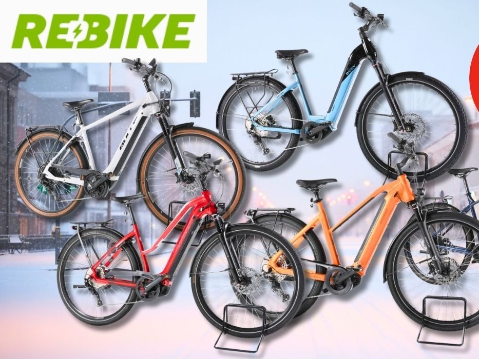 Verschiedene Trekking-, City- und Mountain-E-Bike Modelle. Im Hintergrund eine schneebedecktes Stadtzentrum am frühen Abend in blau-rotem Licht.