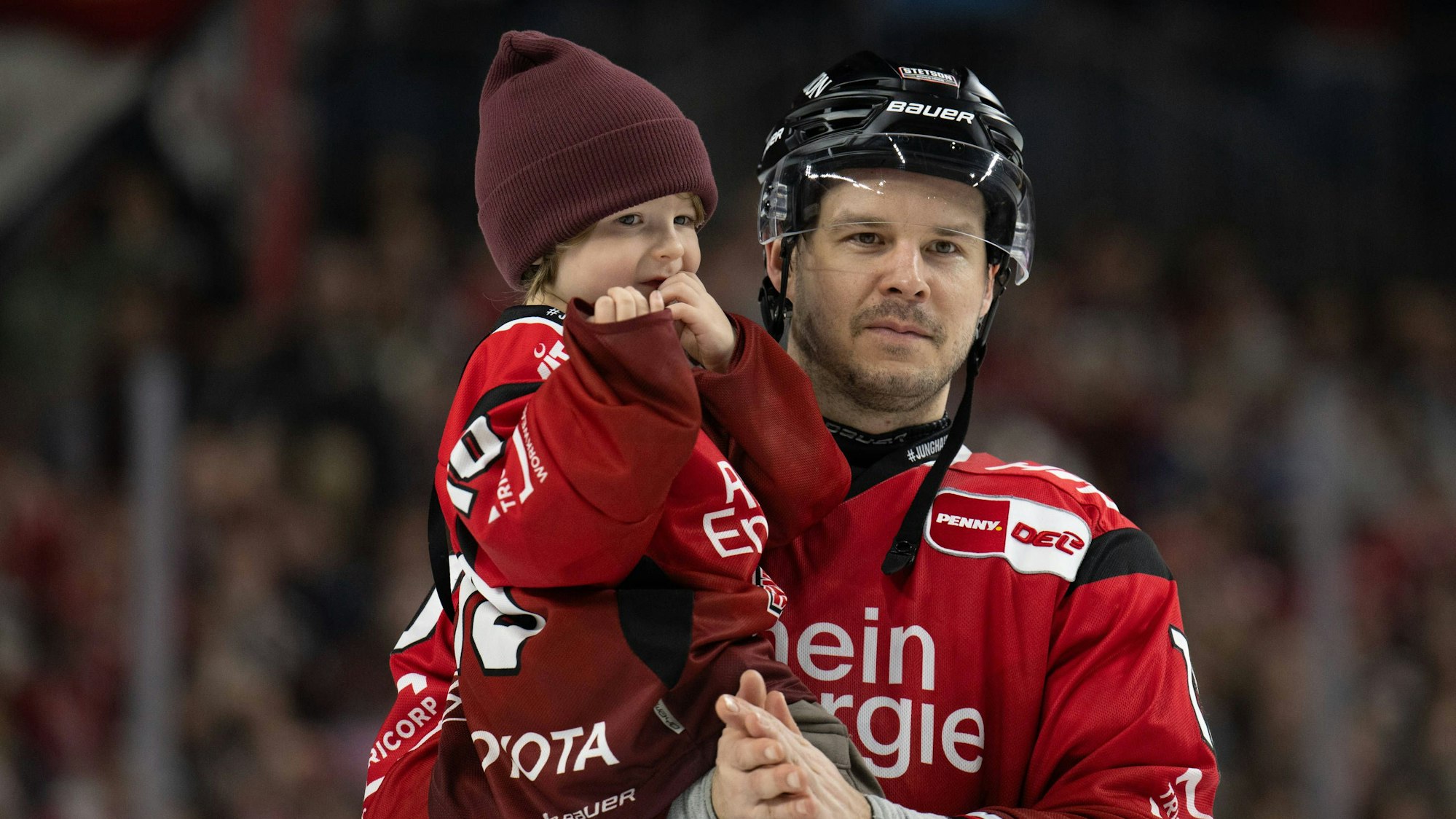 Tanner Keri mit seinem Kind auf dem Eis nach einem Spiel der Kölner Haie.