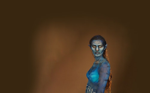 Eine Frau ist als blaue Hauptfigur aus dem Film „Avatar – Aufbruch nach Pandora“ geschminkt und verkleidet.