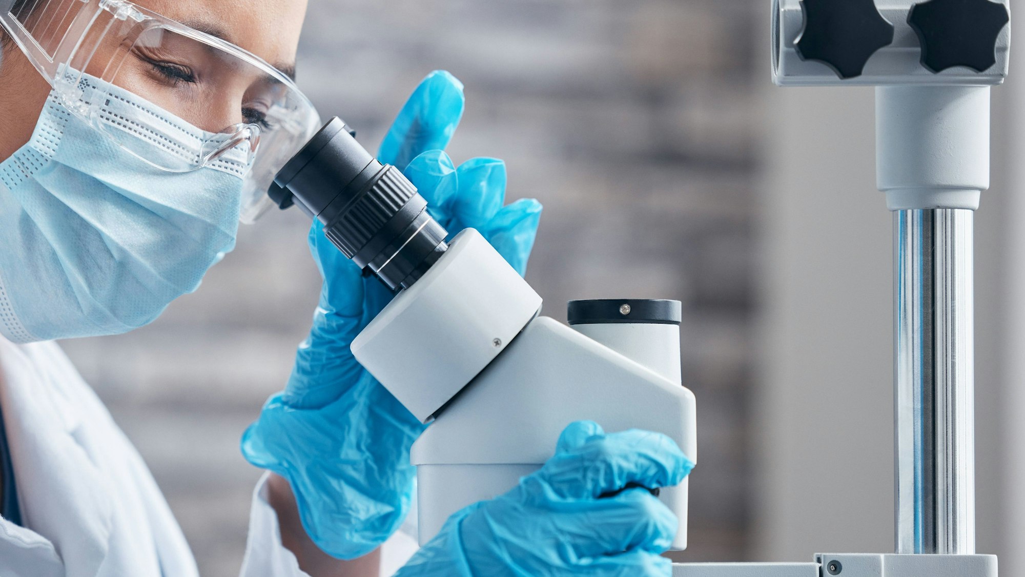 Wissenschaftler blickt durch Mikroskop im Labor