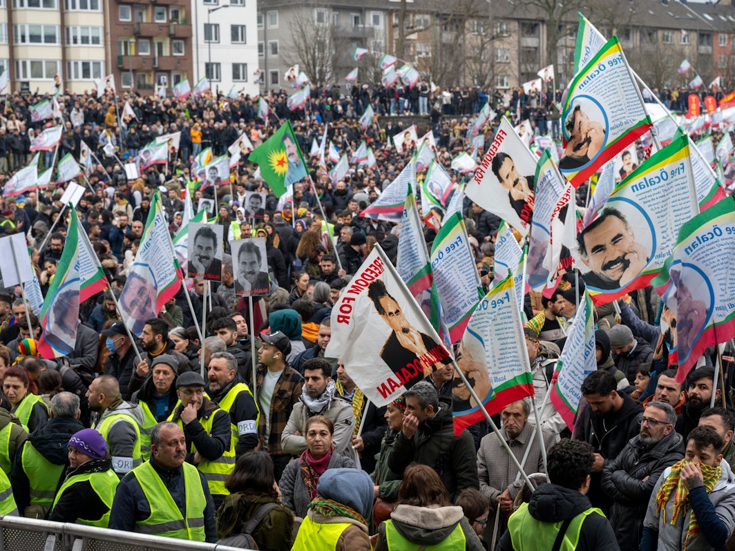 Unzählige Demonstrierende stehen zusammen, viele schwenken Fahnen.