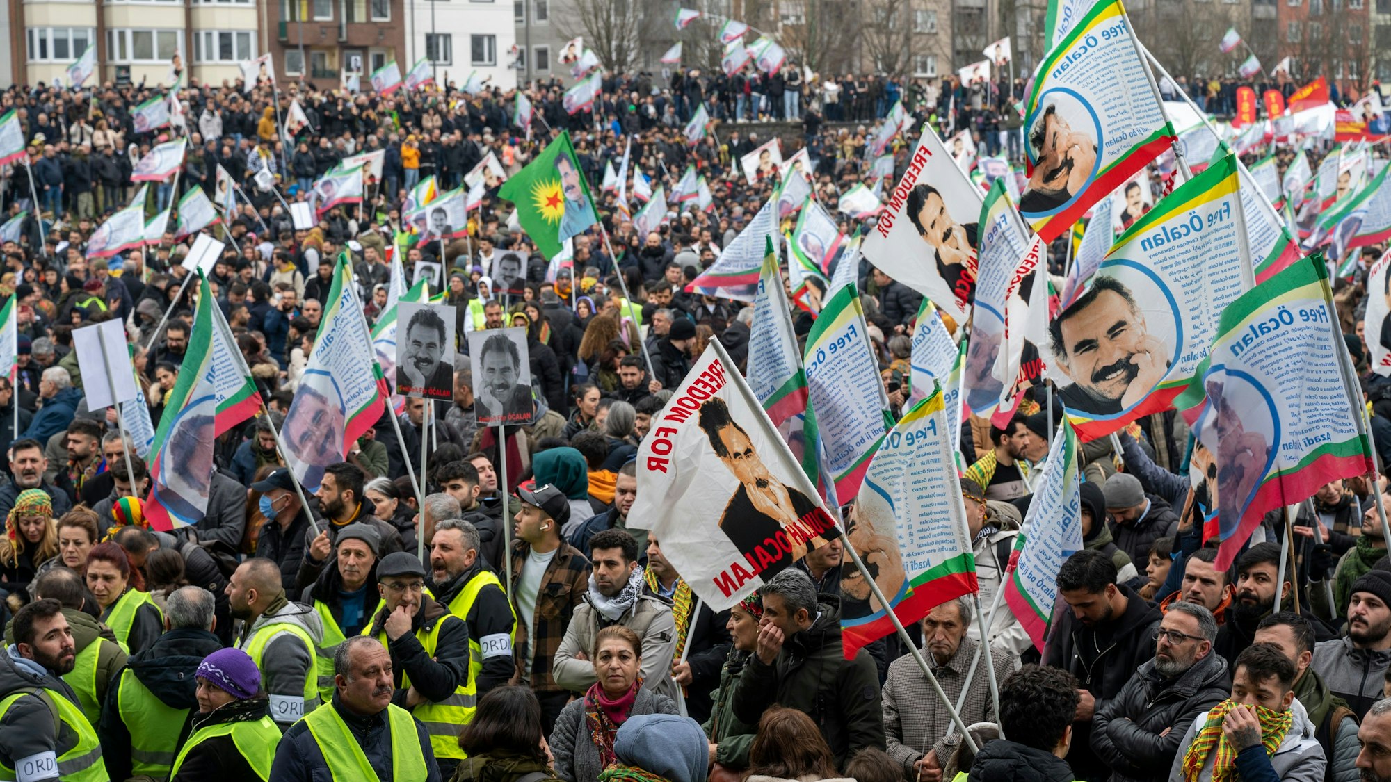 Unzählige Demonstrierende stehen zusammen, viele schwenken Fahnen.