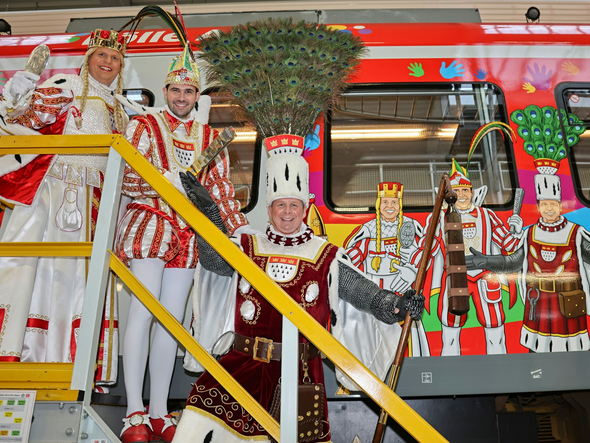 Das Kölner Dreigestirn steht vor der jecken S-Bahn.