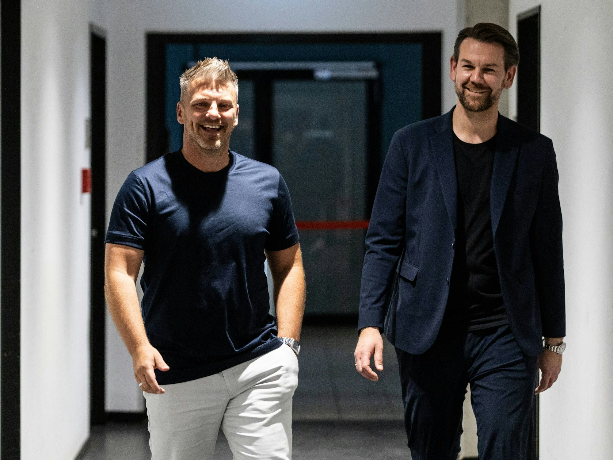 Lukas Kwasniok, Cheftrainer des 1.FC Köln, und Sportchef Thomas Kessler (r.) gehen durch den Flur zur Pressekonferenz im Rhein-Energie-Stadion.