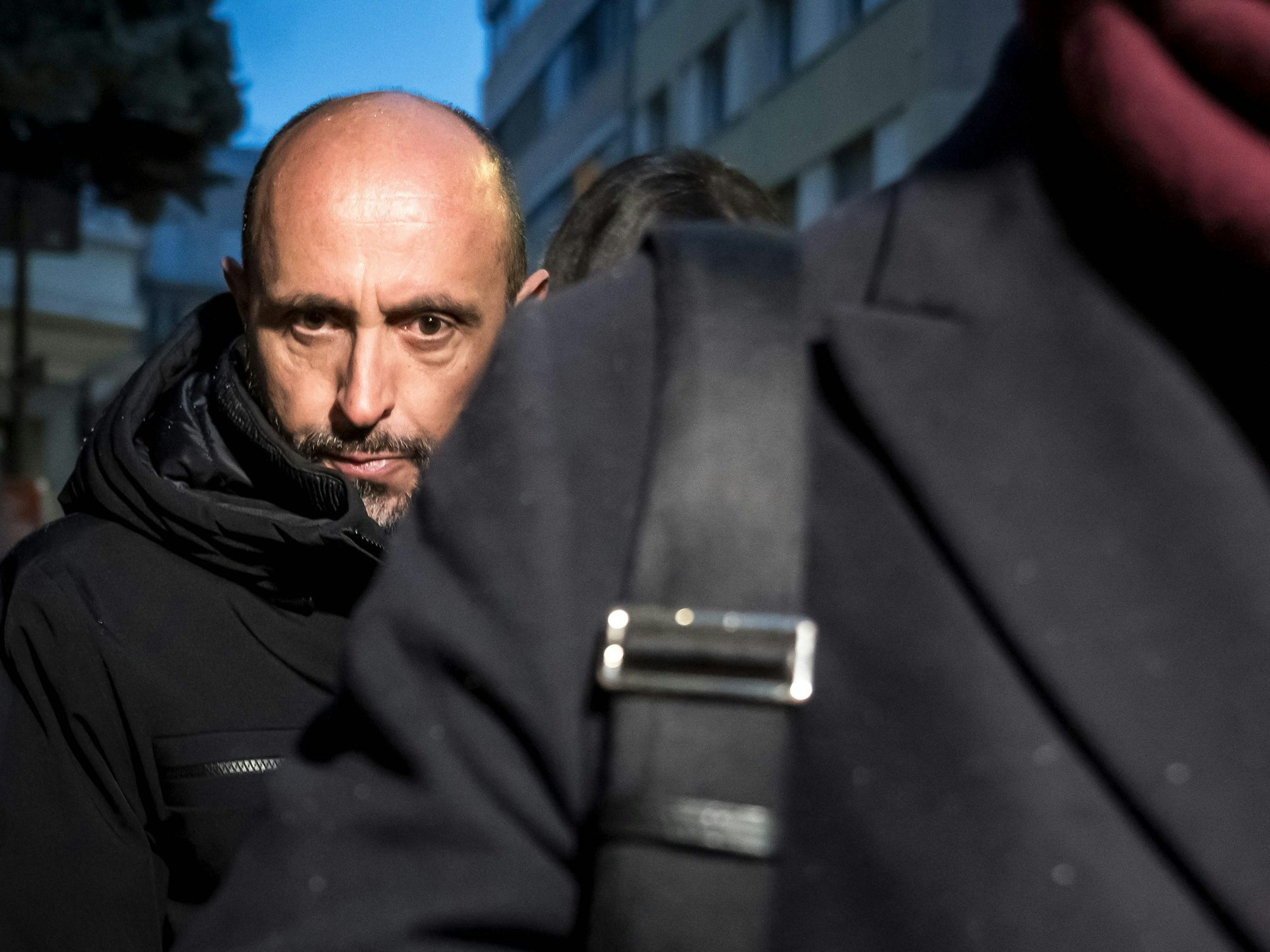 Jacques Moretti geht hinter einer anderen Person her.