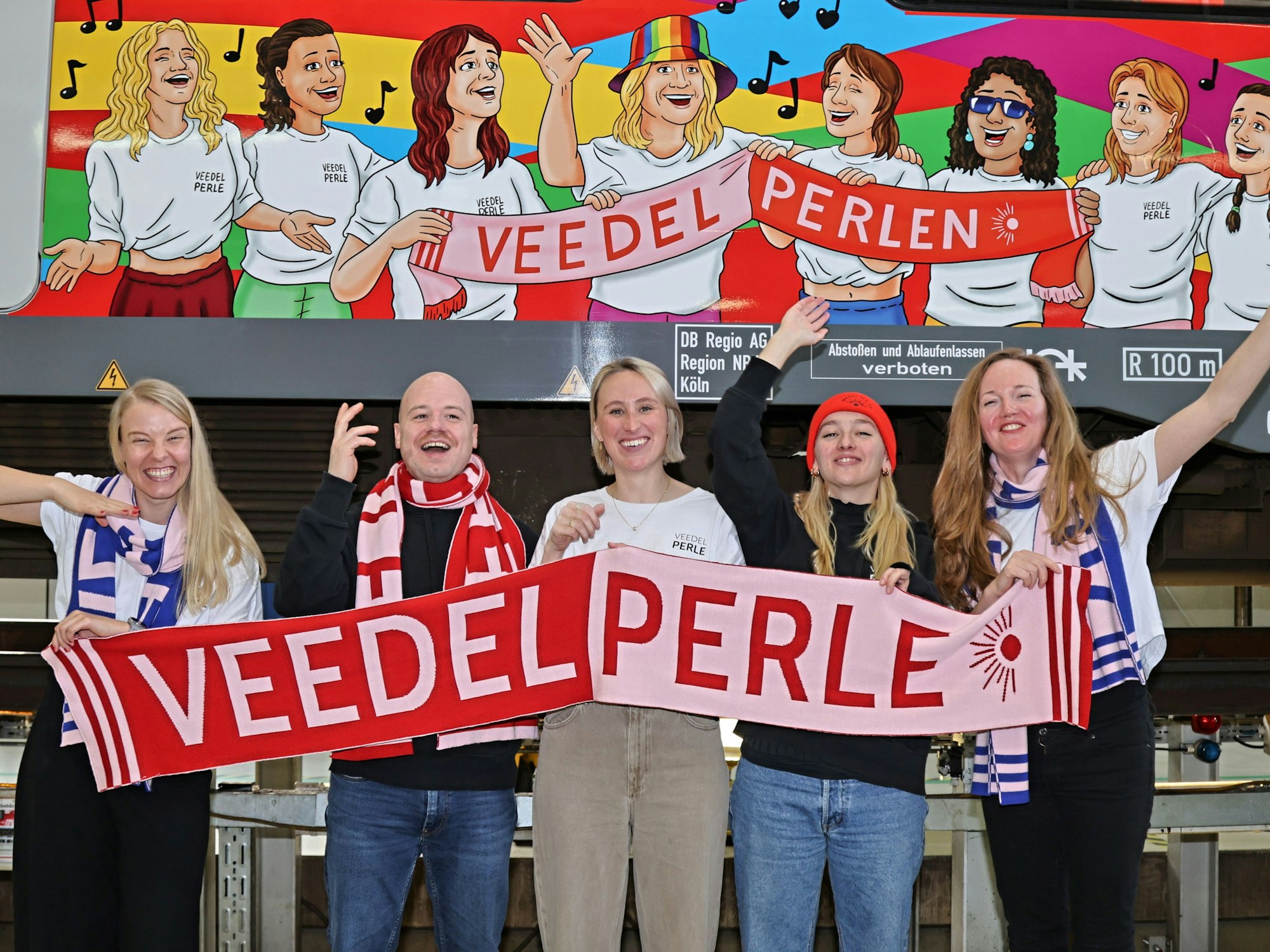 Die Veedelperlen stehen vor der S-Bahn.