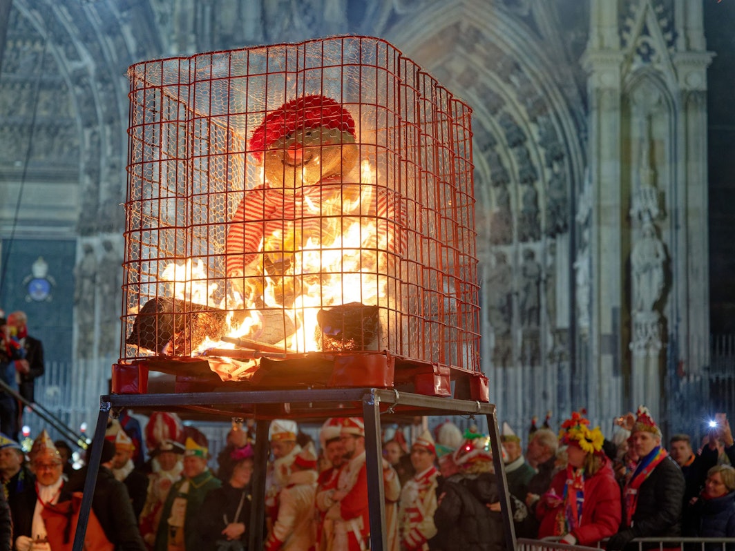 Karnevalisten beobachten die „Nubbel-Verbrennung“ vor dem Kölner Dom.