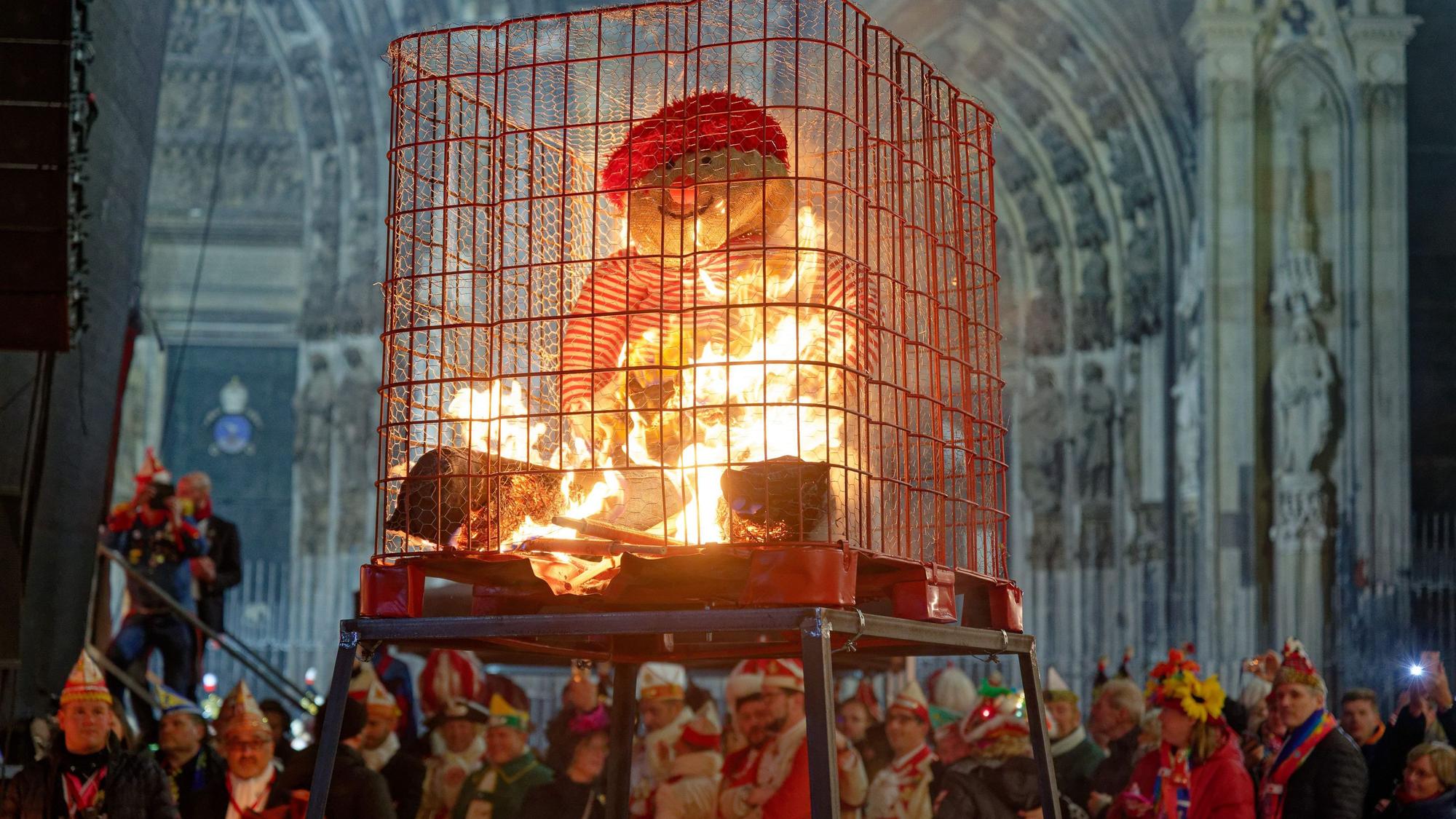 Karnevalisten beobachten die „Nubbel-Verbrennung“ vor dem Kölner Dom.