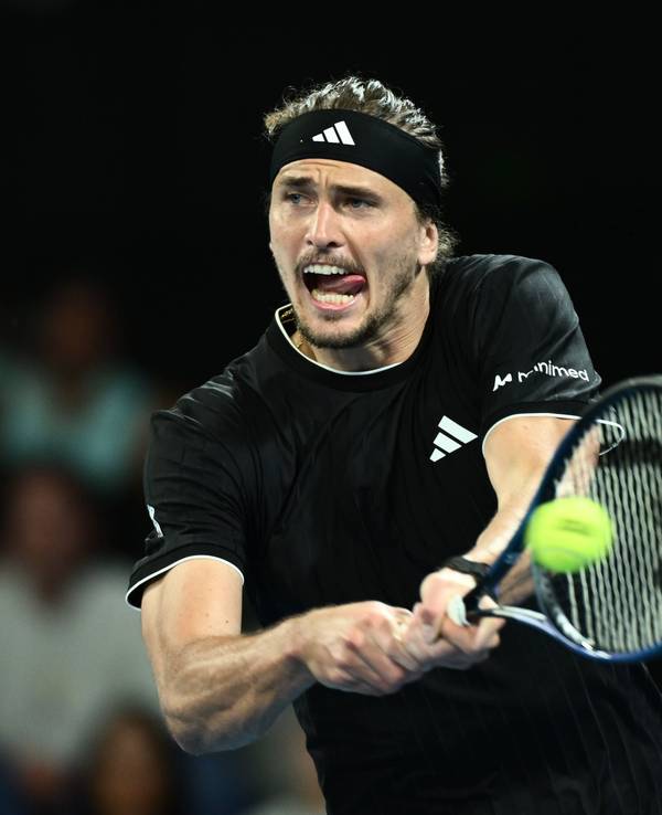 Alexander Zverev streckt bei einem Schlag die Zunge raus.