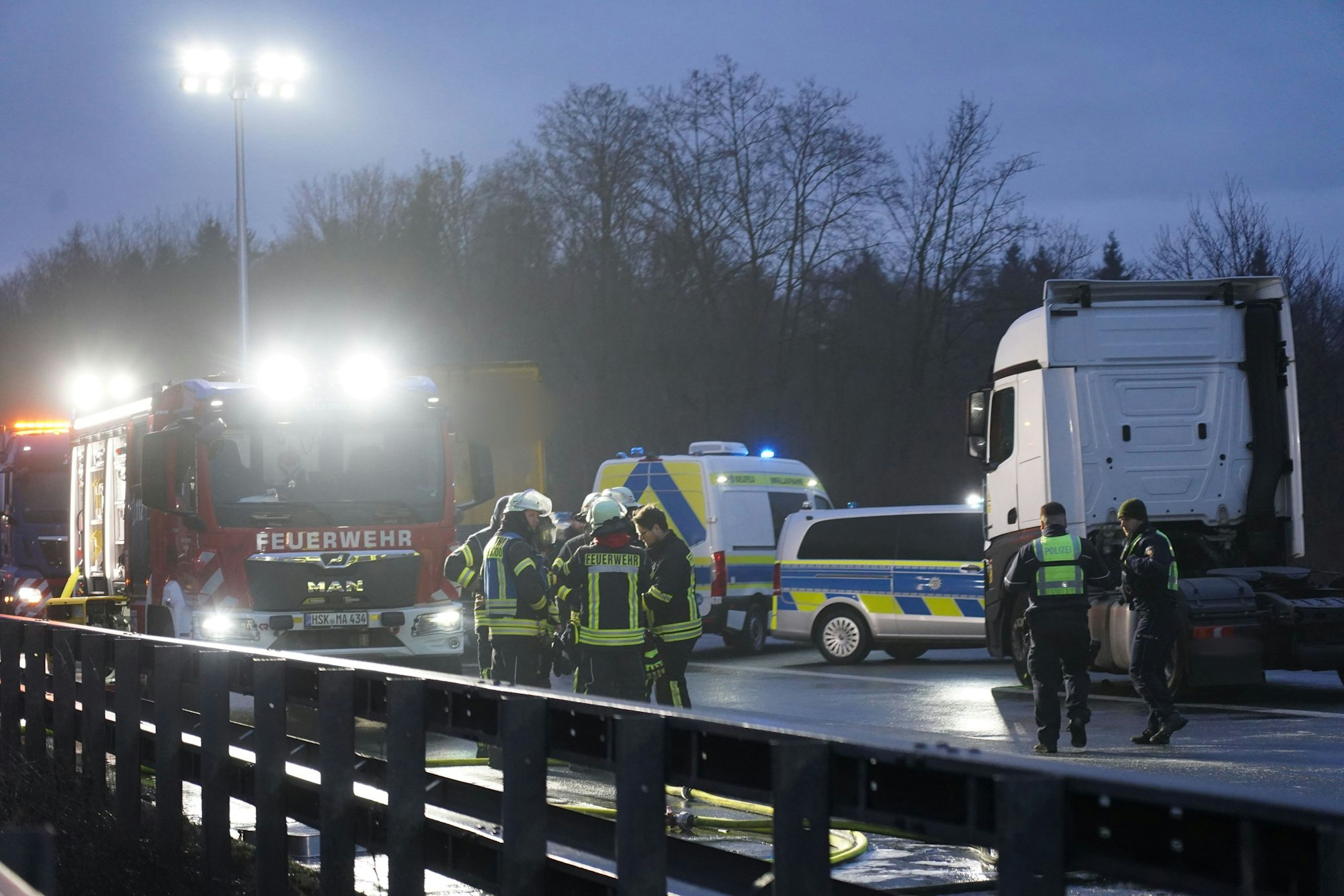 Beschädigte Fahrzeuge, Feuerwehr und Polizei stehen auf der Fahrbahn nach einer durch Glätte ausgelösten Unfallserie mit mehreren Toten und vielen Verletzten auf der A44. Christian Müller/dpa