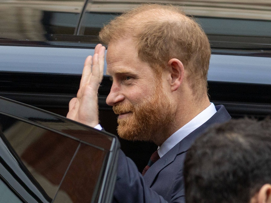Prince Harry winkt aus einem Fahrzeug