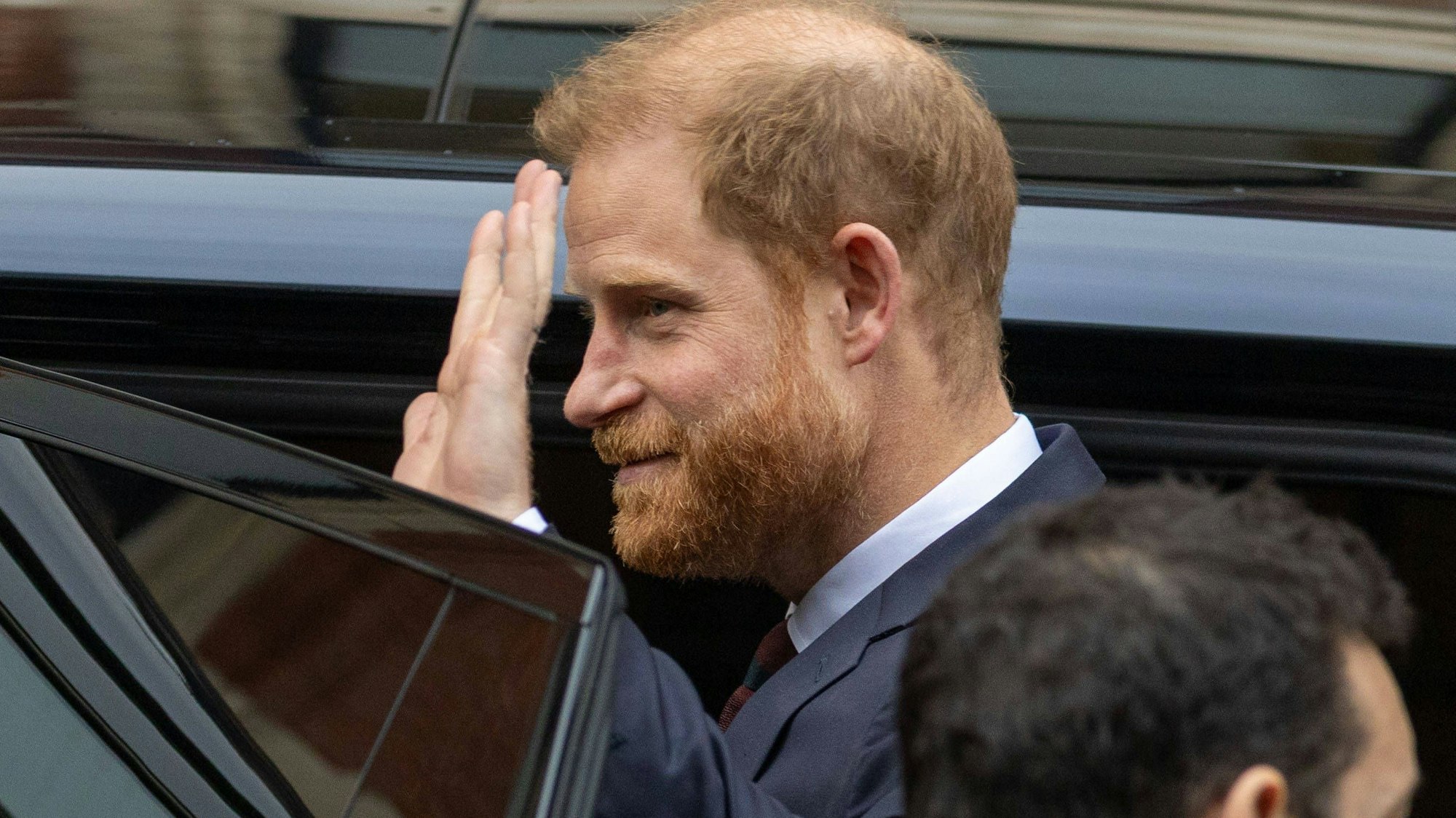 Prince Harry winkt aus einem Fahrzeug
