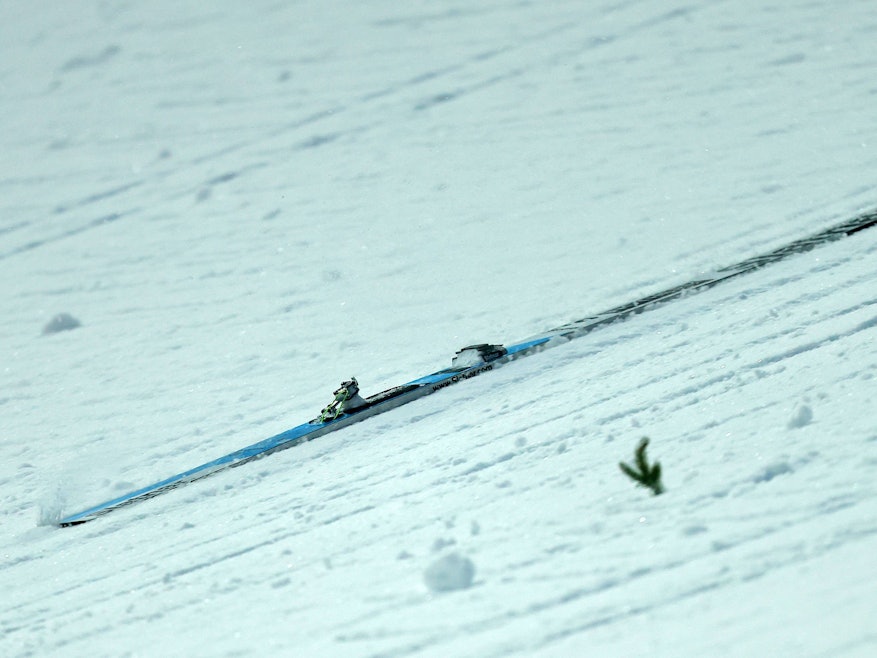 Ein Skir rutsct den Hang hinunter.