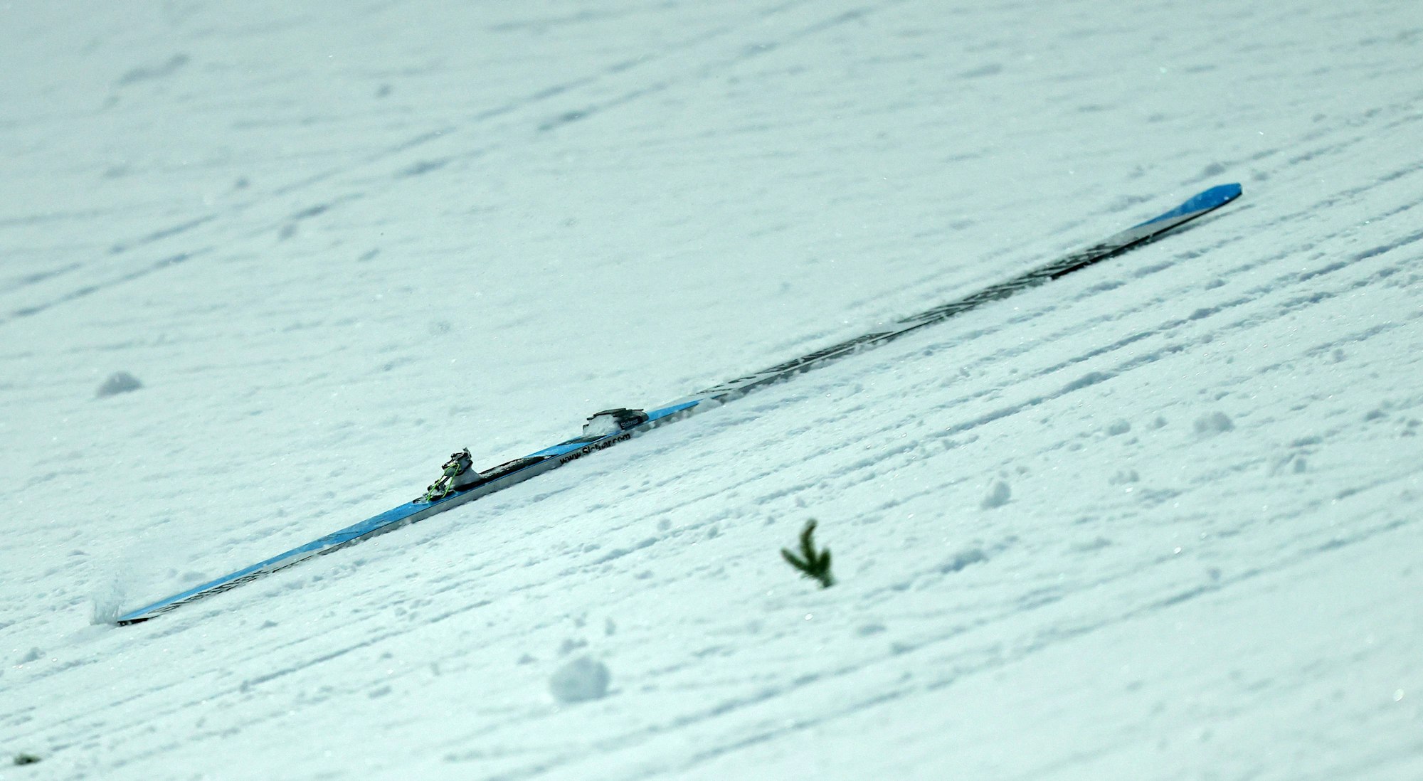 Ein Skir rutsct den Hang hinunter.
