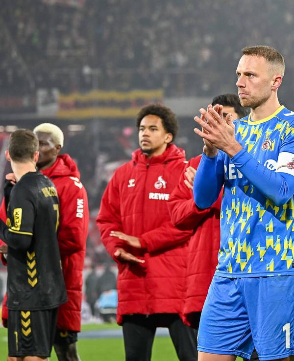 Marvin Schwäbe klatscht vor den Fans in die Hände, im Hintergrund stehen weitere Spieler.