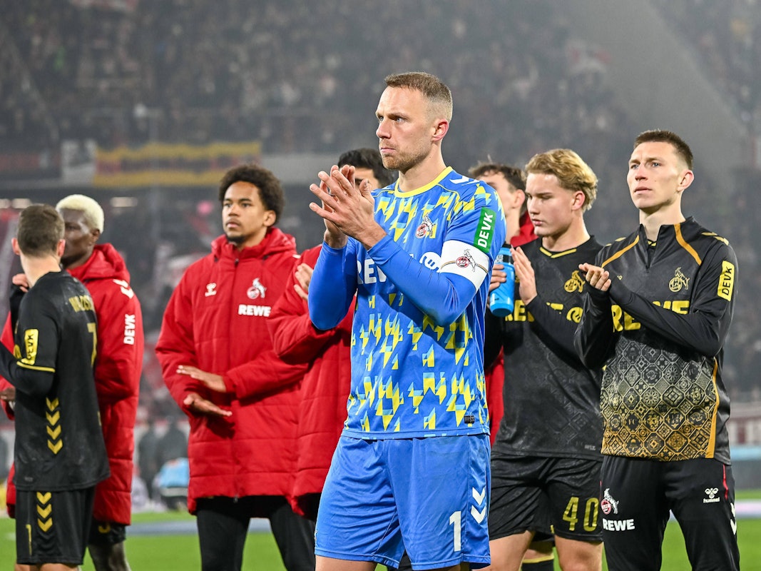 Marvin Schwäbe klatscht vor den Fans in die Hände, im Hintergrund stehen weitere Spieler.