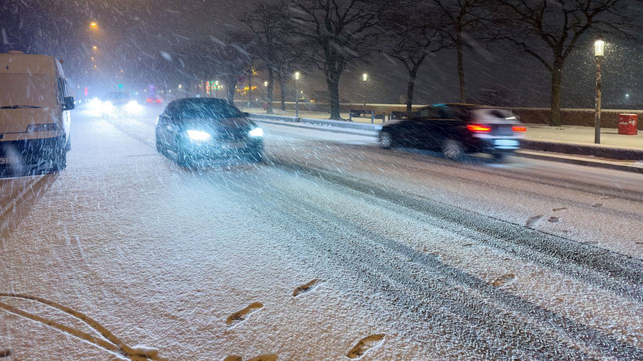 Schnee fällt am späten Samstagabend (24. Januar) auf einer Straße am Hafen in Hamburg.