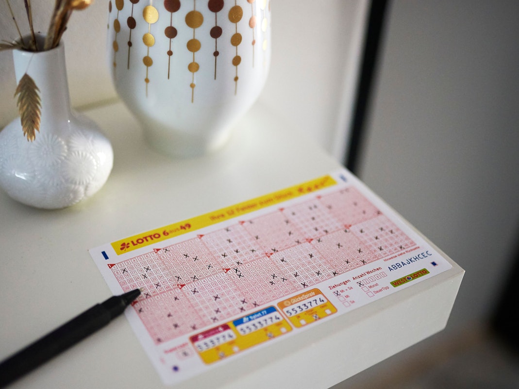 Ein LOTTO 6aus49 Schein liegt auf einem Tisch.