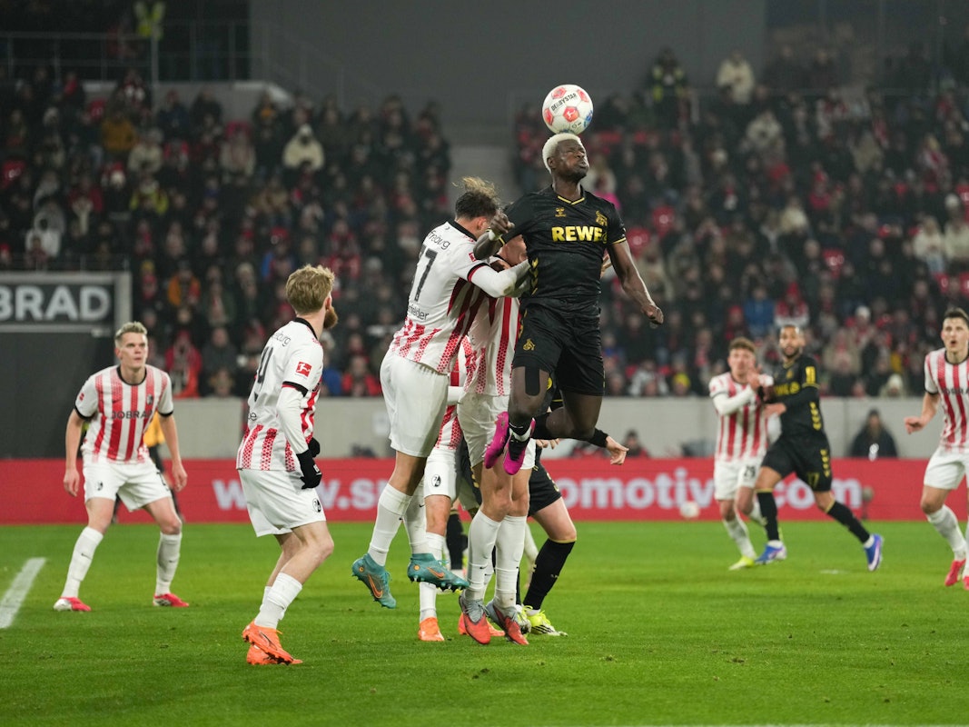Ragnar Ache (1. FC Köln) gewinnt ein Kopfballduell im Spiel beim SC Freiburg am 25. Januar 2026.