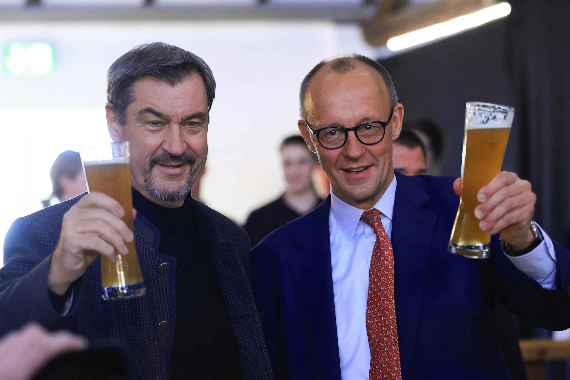 Bundeskanzler Friedrich Merz (r.) und CSU-Chef Markus Söder mit Biergläsern in der Hand.