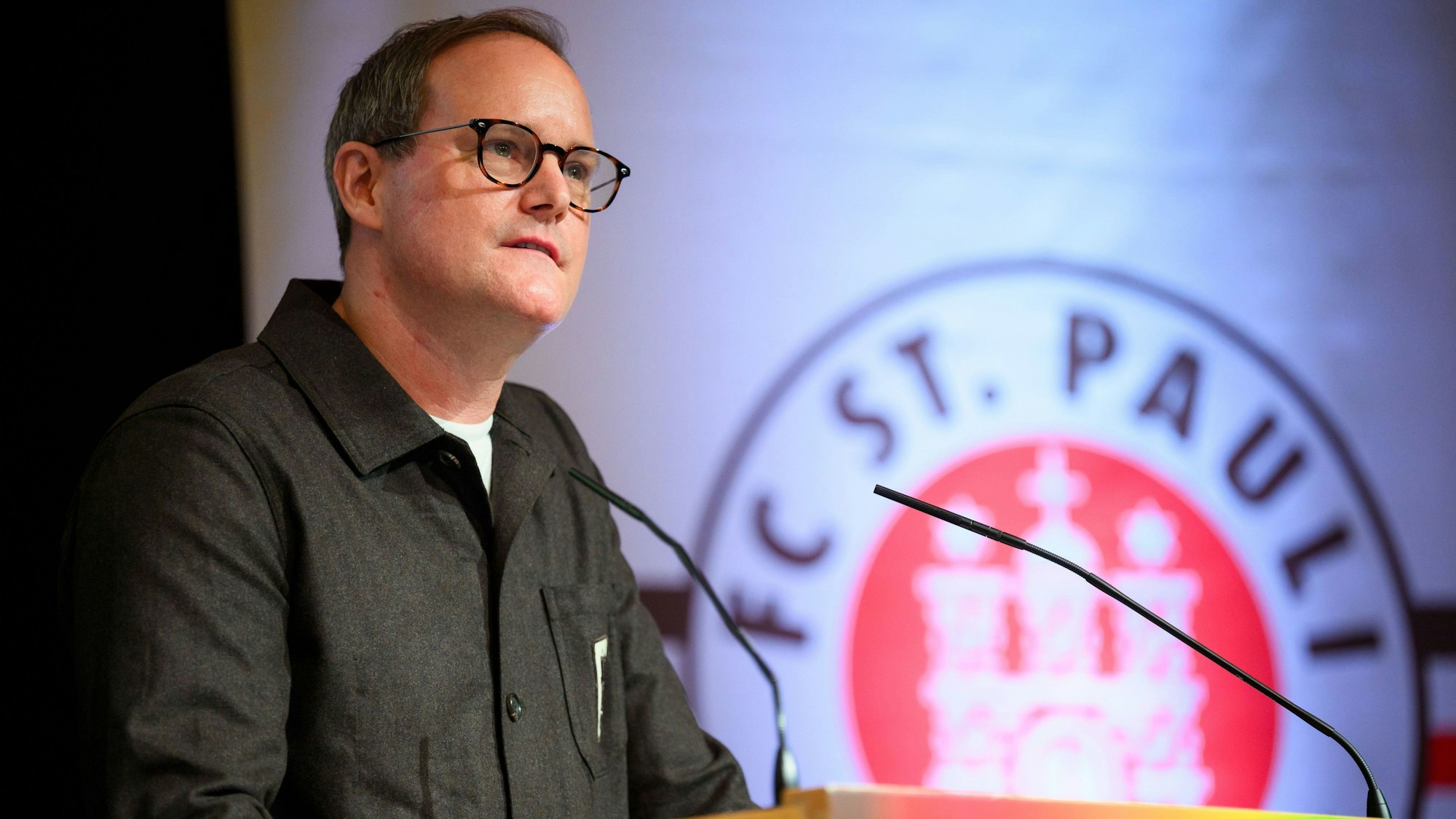 DFB-Vizepräsident und St.-Pauli-Clubchef Oke Göttlich steht bei einer Mitgliederversammlung am Rednerpult.