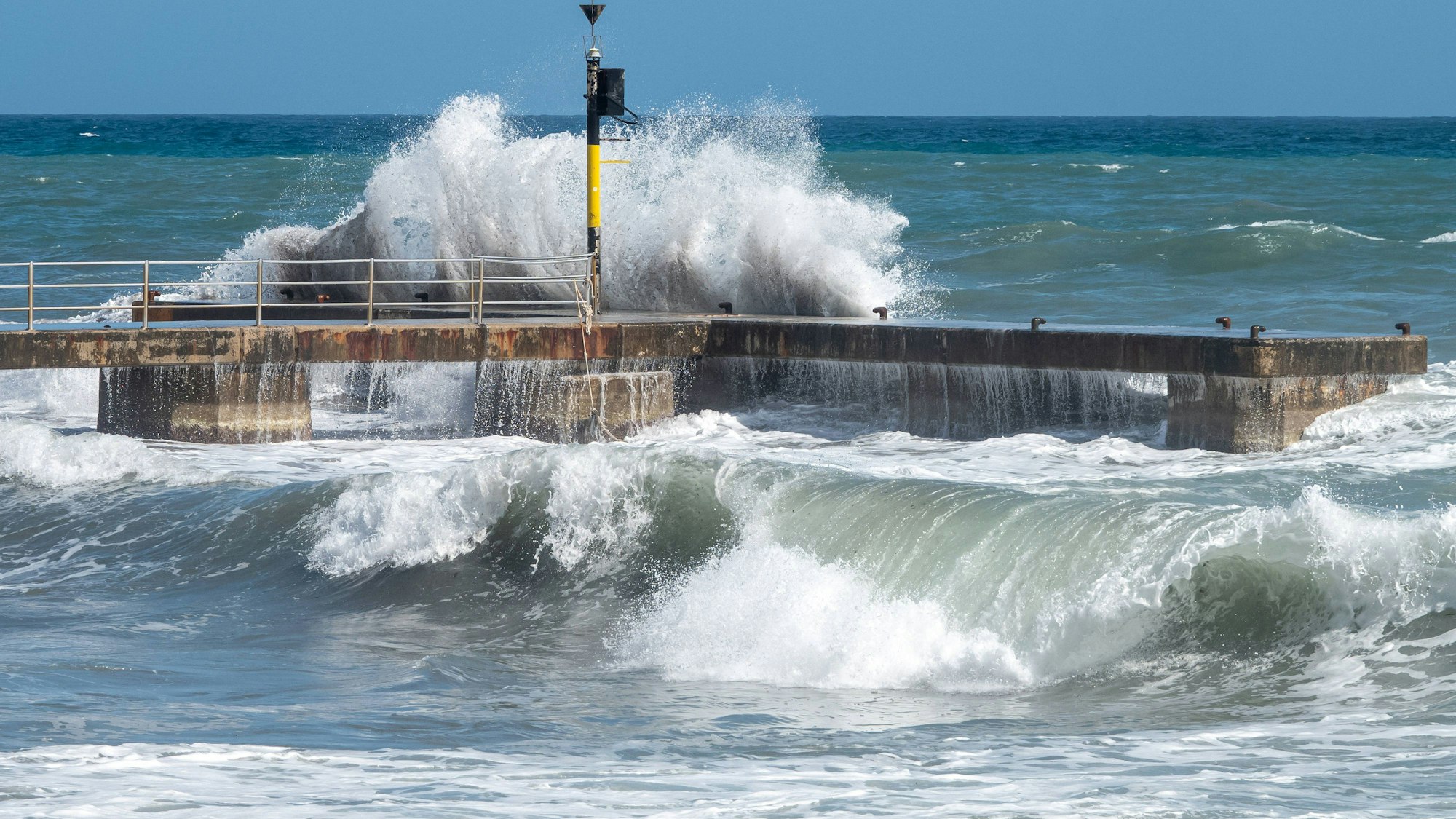 Hohe Wellen an einem Bootsanleger im Meer