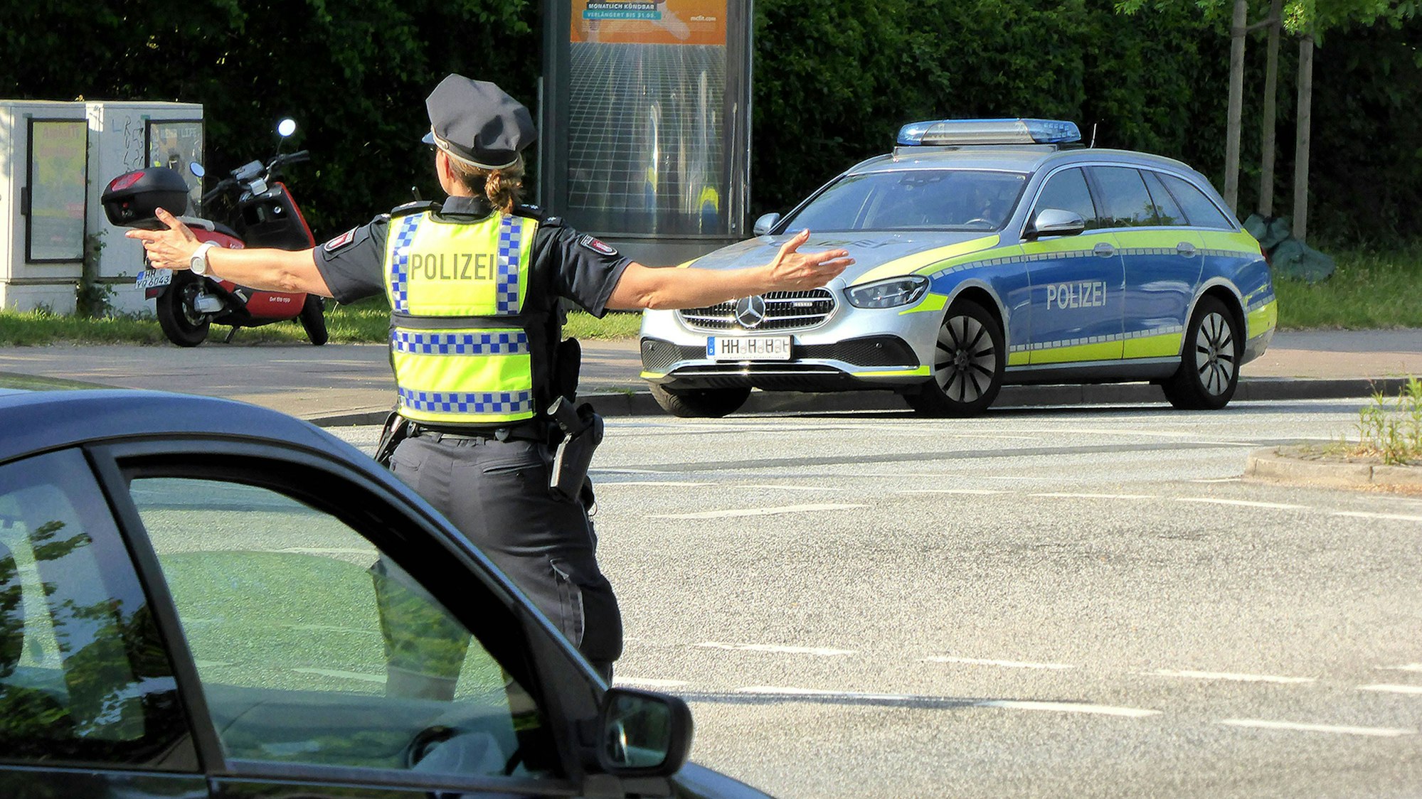 Polizistin regelt Verkehr, Polizeifahrzeug auf Strasse