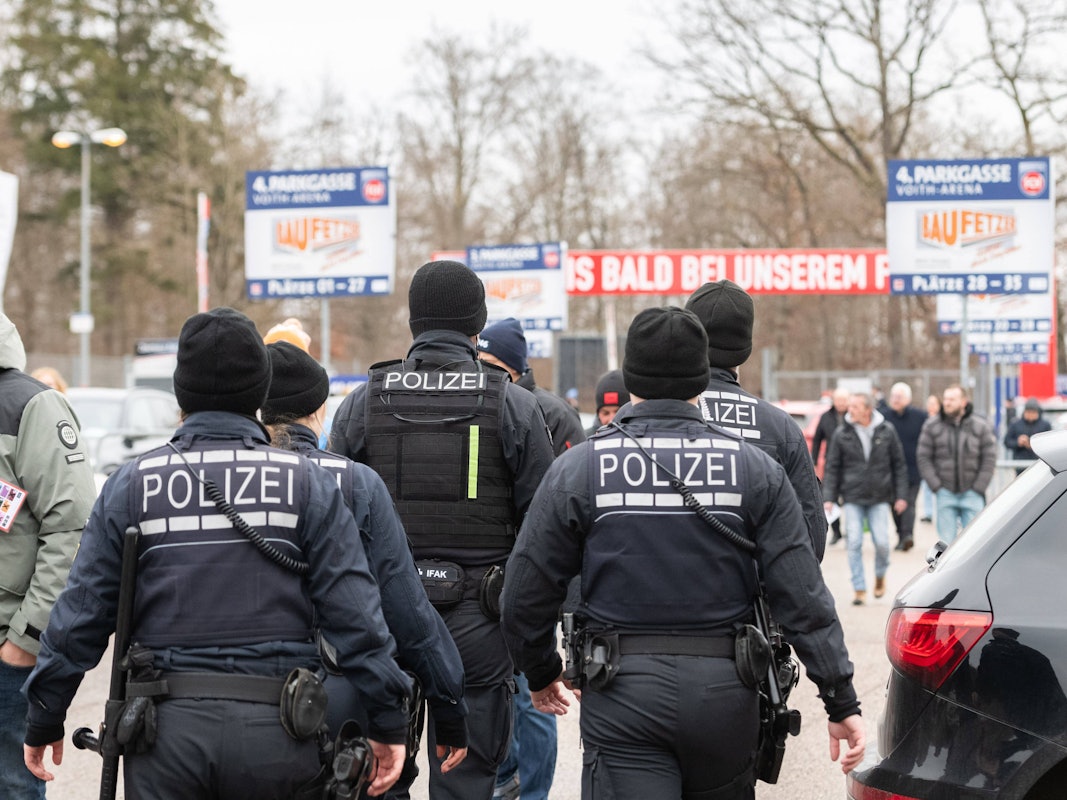 Polizeikräfte gehen auf das Stadion des 1. FC Heidenheim zu.