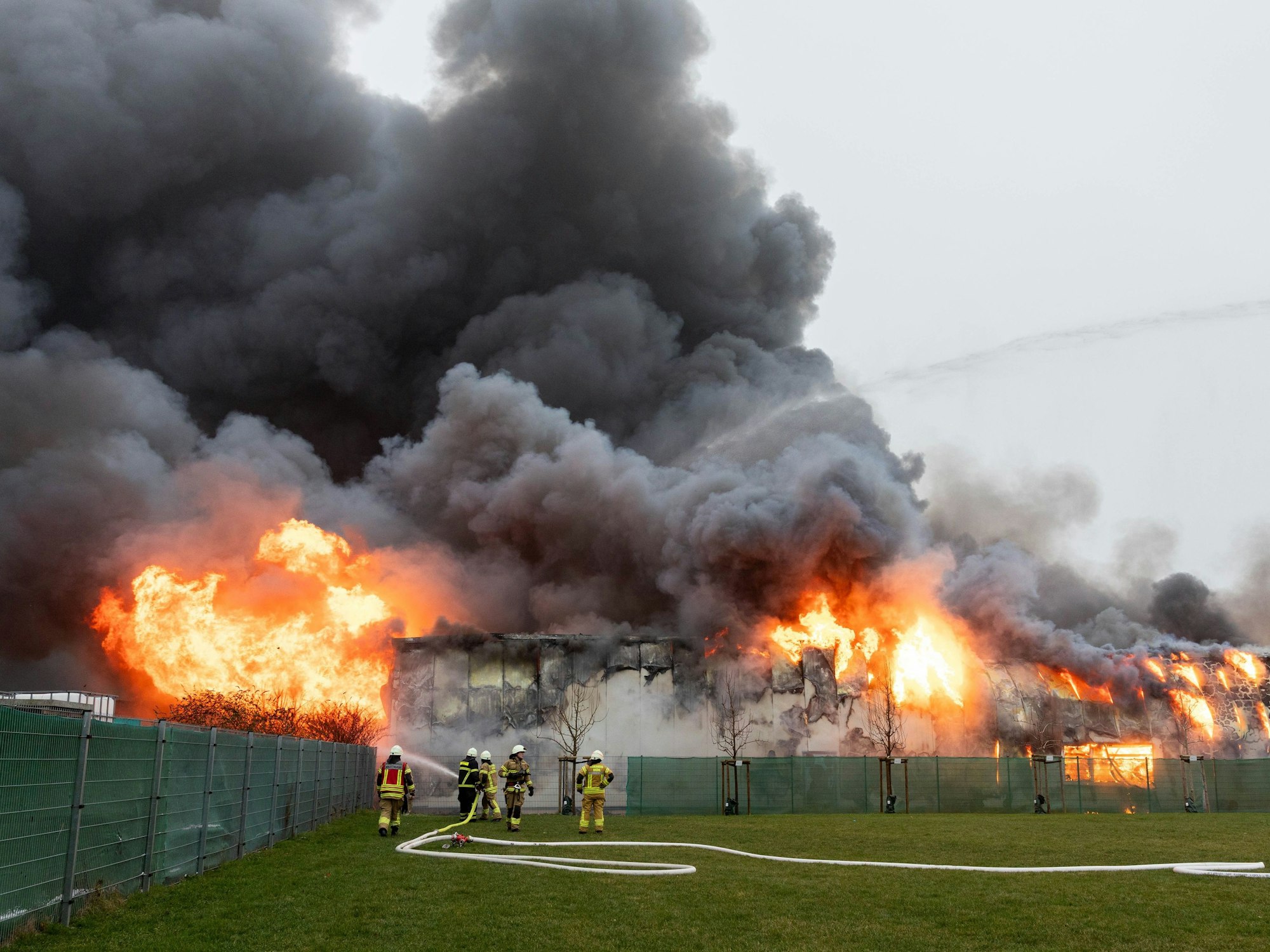 Einsatzkräfte bekämpfen den Brand einer Lagerhalle in Hürth.
