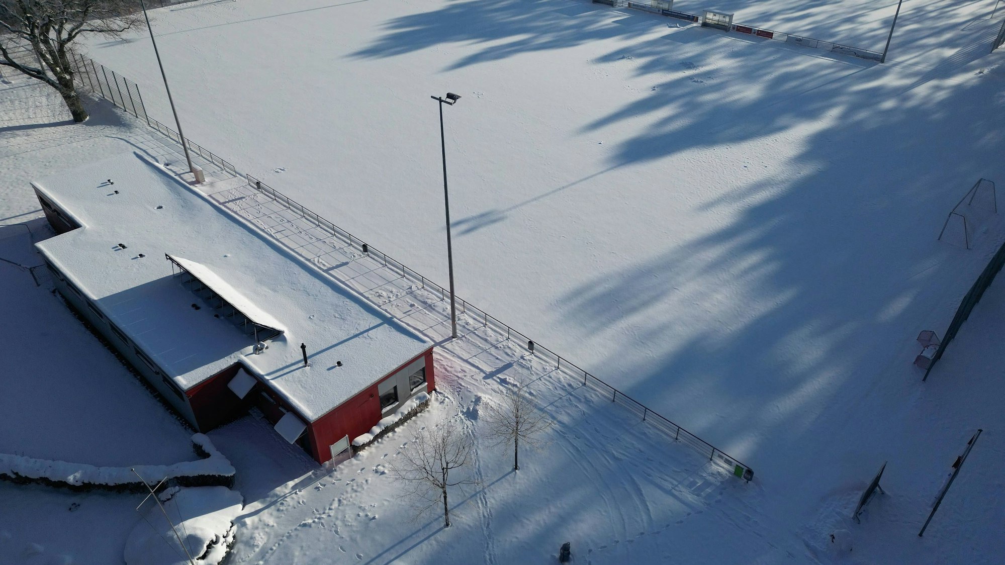 Vollständig verschneiter Sportplatz mit angrenzendem Gebäude
