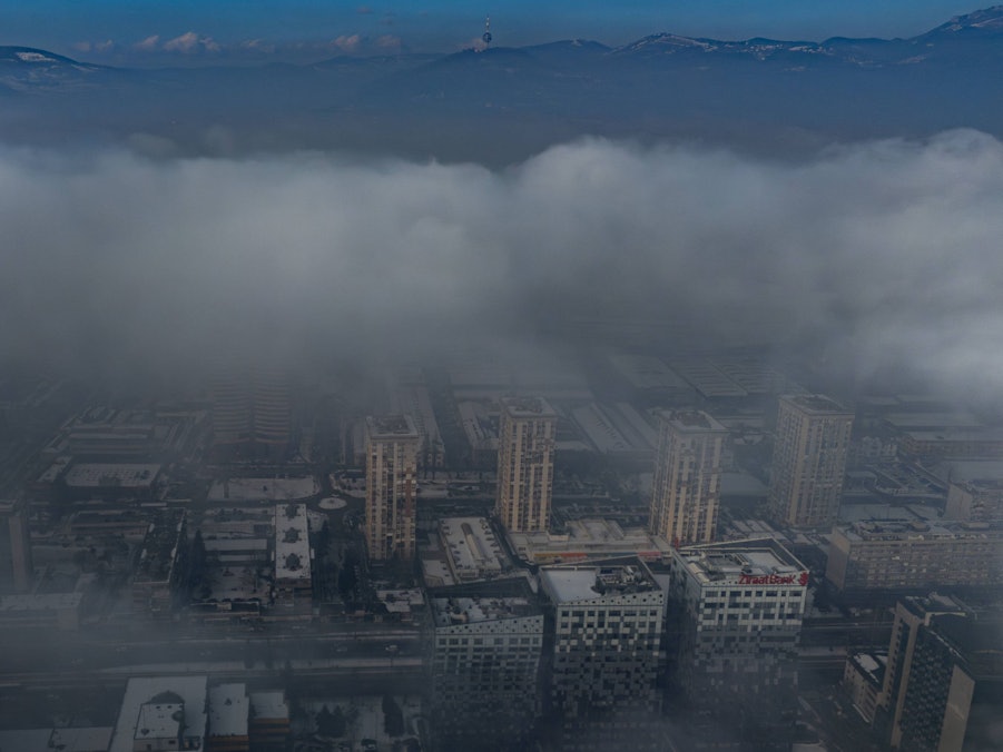Stadtlandschaft unter Nebel mit fernen Bergen