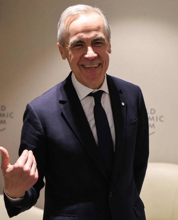 Ein Mann mit grauem Haar, in Anzug und mit Krawatte, gestikuliert und lacht dabei in die Kamera.