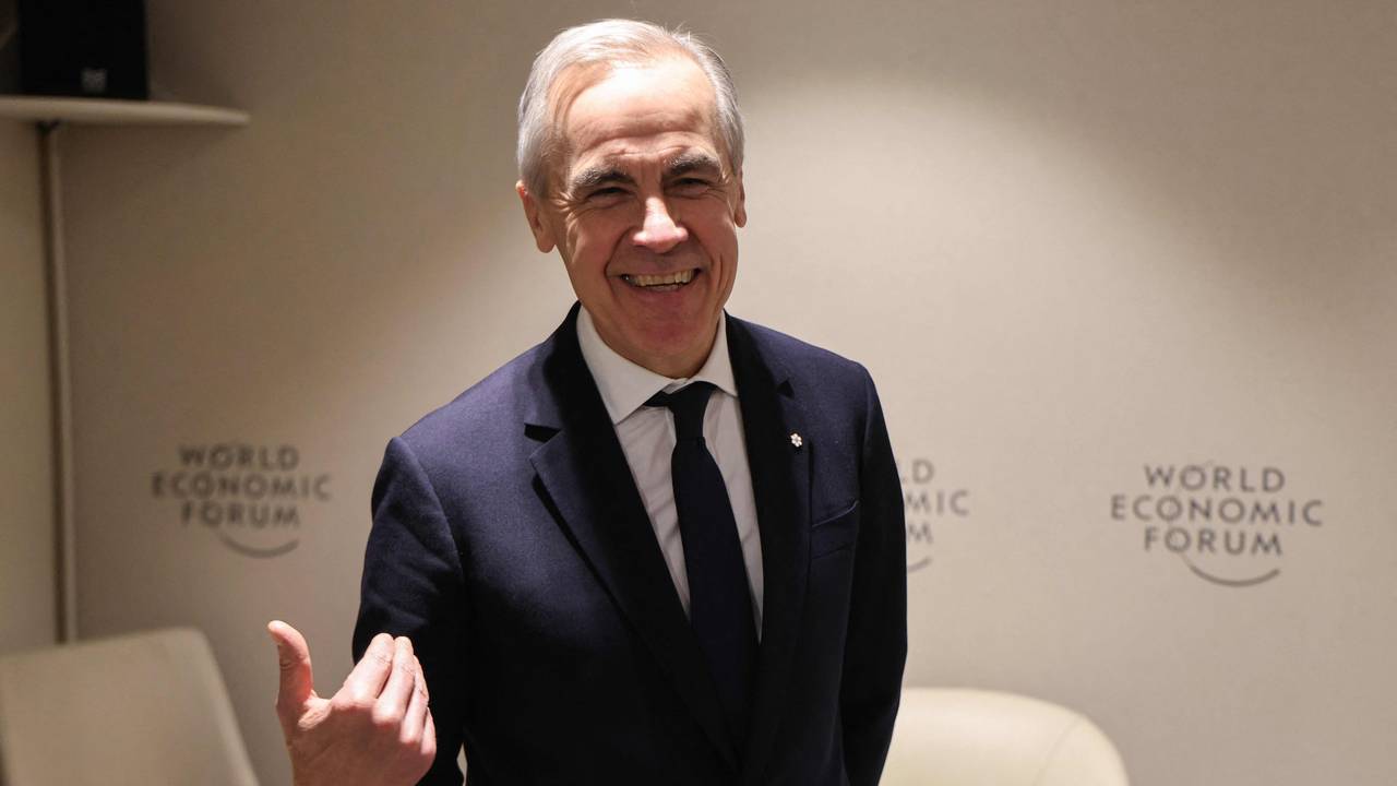 Ein Mann mit grauem Haar, in Anzug und mit Krawatte, gestikuliert und lacht dabei in die Kamera.
