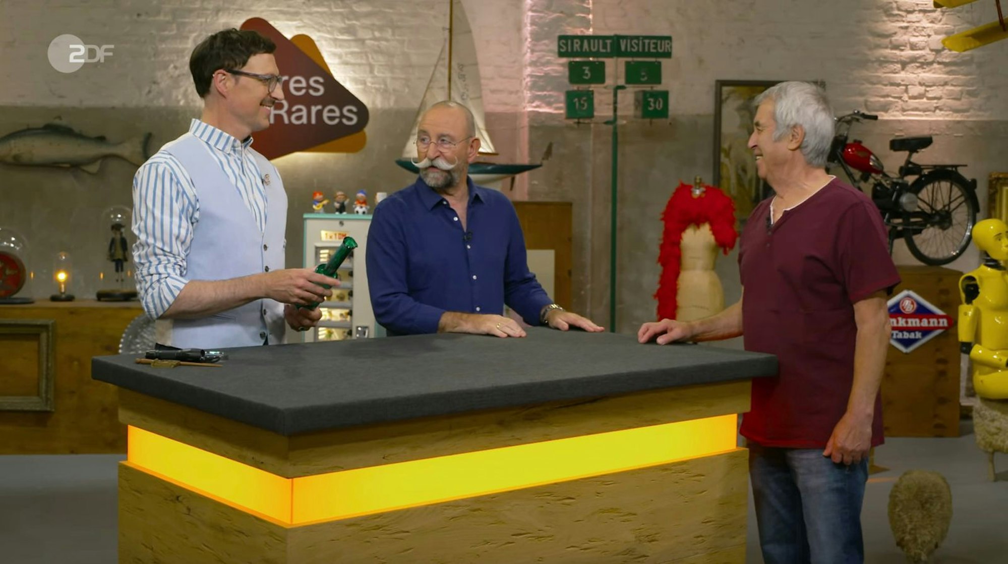 Eine Flaschenvase der finnischen Designerin Nanny Still aus den 1960er Jahren schätzte Colmar Schulte-Goltz auf 200 bis 250 Euro. Der Verkäufer wollte 180 Euro für das Kunstglas. Im Händlerraum wurde kurz über den Begriff „Vase“ diskutiert. Denn Suppes erinnerte das Stück eher an eine Karaffe. Am Ende zahlte Jos van Katwijk 200 Euro. (Bild: ZDF)