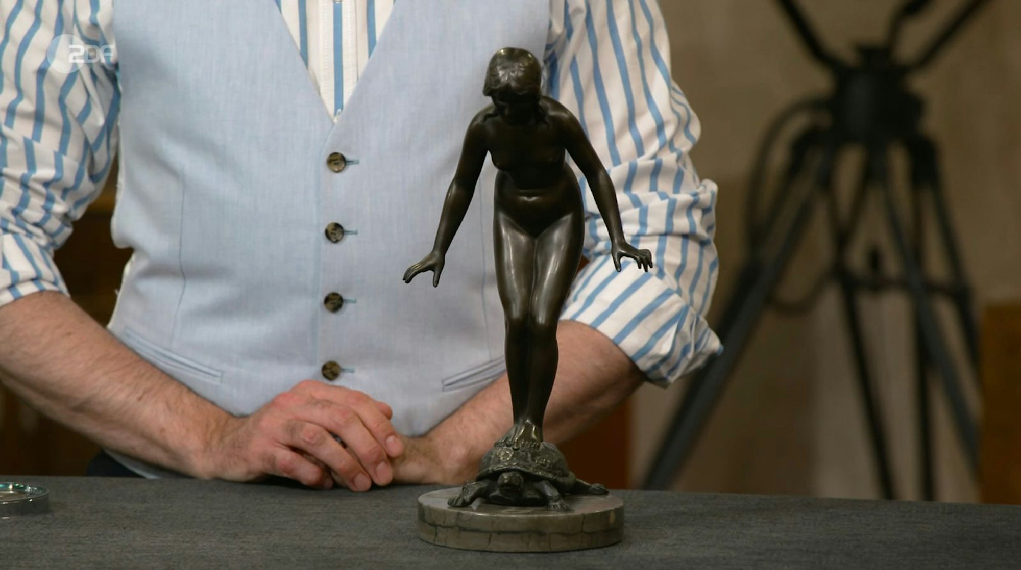 Colmar Schulte-Goltz erklärte, die nackte Frau auf der Schildkröte symbolisiere „Balance im Leben“. Entworfen wurde das Original um 1900 von Richard Fabricius, die vorliegende Figur war aber ein Nachguss aus der zweiten Hälfte des 20. Jahrhunderts. Wunschpreis: 1.500 Euro, Schätzung: 500 Euro. Jos van Katwijk zahlte schließlich 350 Euro. (Bild: ZDF)