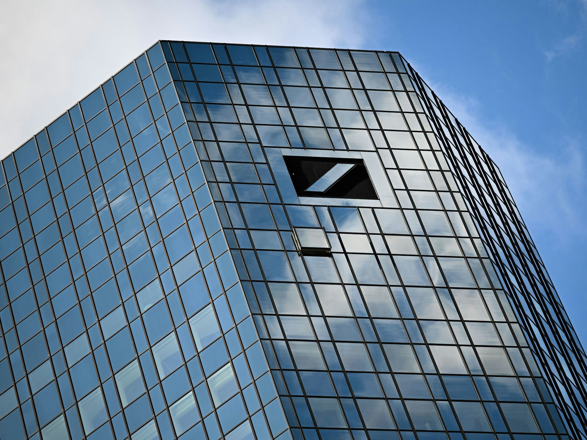 Wolken spiegeln sich in der Glasfassade der Zwillingstürme der Zentrale der Deutschen Bank in Frankfurt/Main.