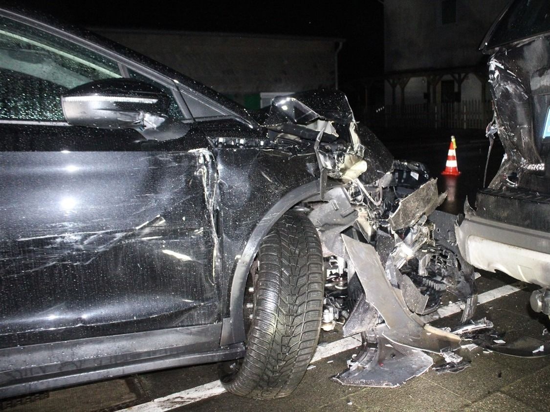 Ein bei einem Unfall stark beschädigtes Auto steht auf einem Gehweg.