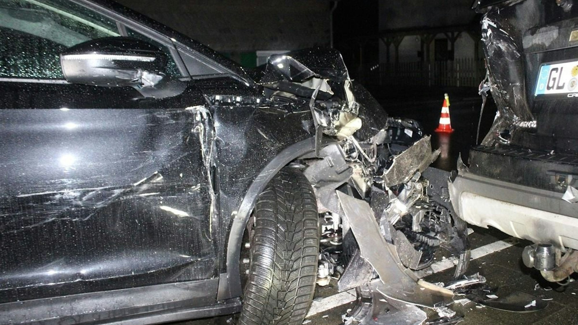 Ein bei einem Unfall stark beschädigtes Auto steht auf einem Gehweg.