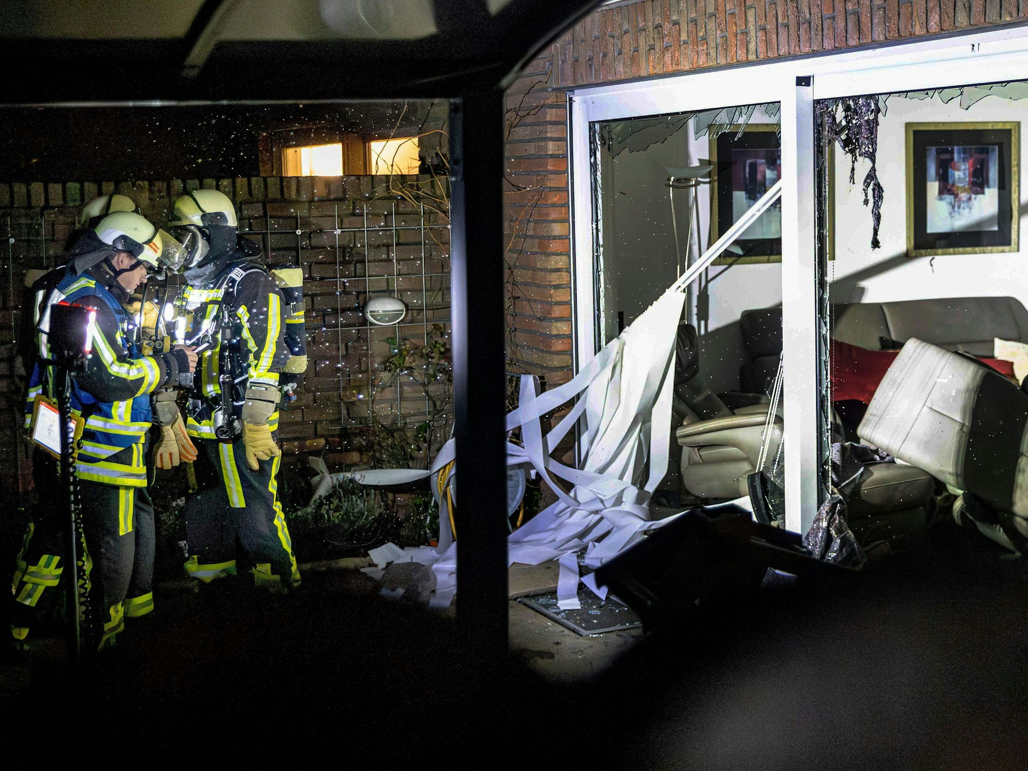 Einsatzkräfte stehen nach einer Explosion neben Trümmern. Bei der schweren Explosion wurde eine Person lebensgefährlich verletzt.