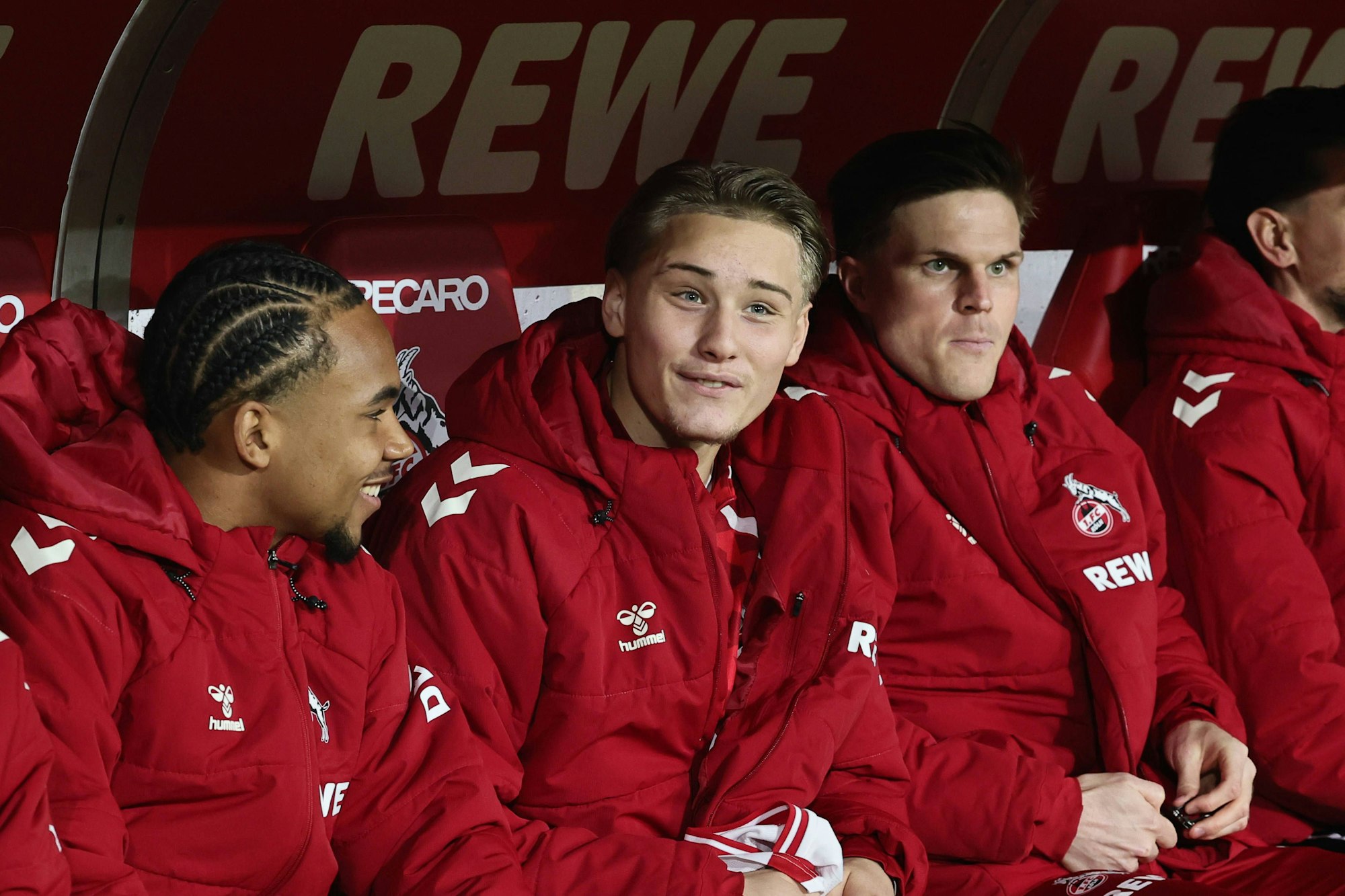 Youssoupha Niang und Fynn Schenten sitzen auf der Ersatzbank neben Marius Bülter.