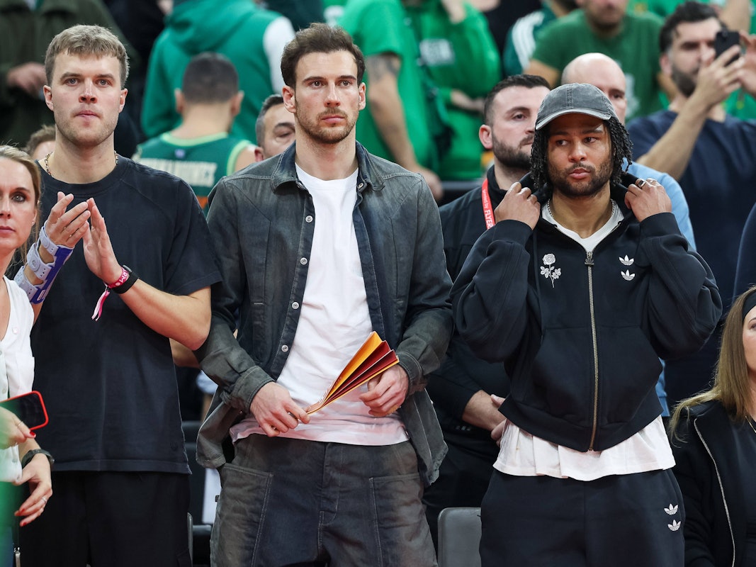 Leon Goretzka und Serge Gnabry stehn am Rande eines Basketballspiels.