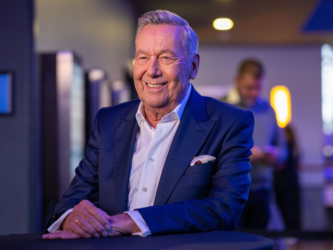 Schlagerstar Roland Kaiser sitzt lächelnd auf einem Stuhl