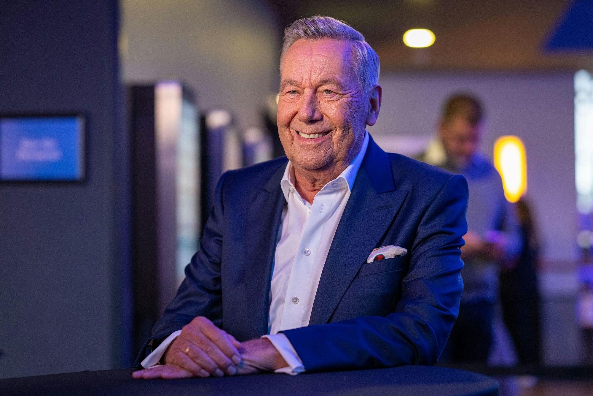 Schlagerstar Roland Kaiser sitzt lächelnd auf einem Stuhl