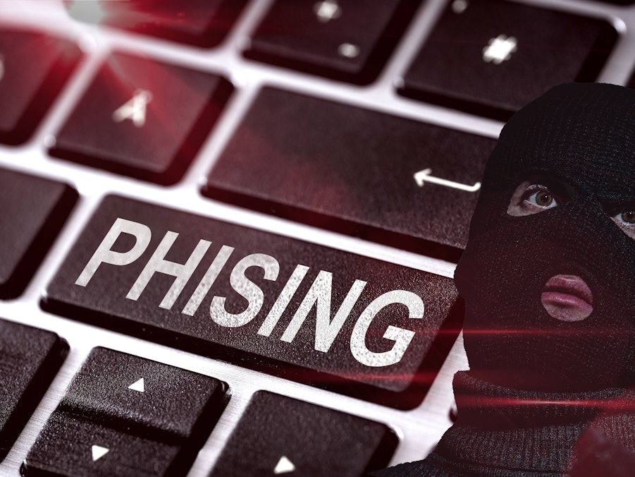 Maskierte Person und Phishing-Tastatur